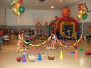 A party room with balloons and cones around it.